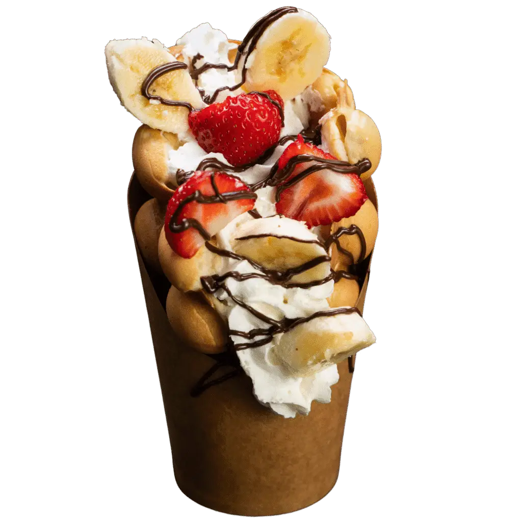 Bubble waffle topped with banana slices, fresh strawberries, whipped cream and dark chocolate drizzle.