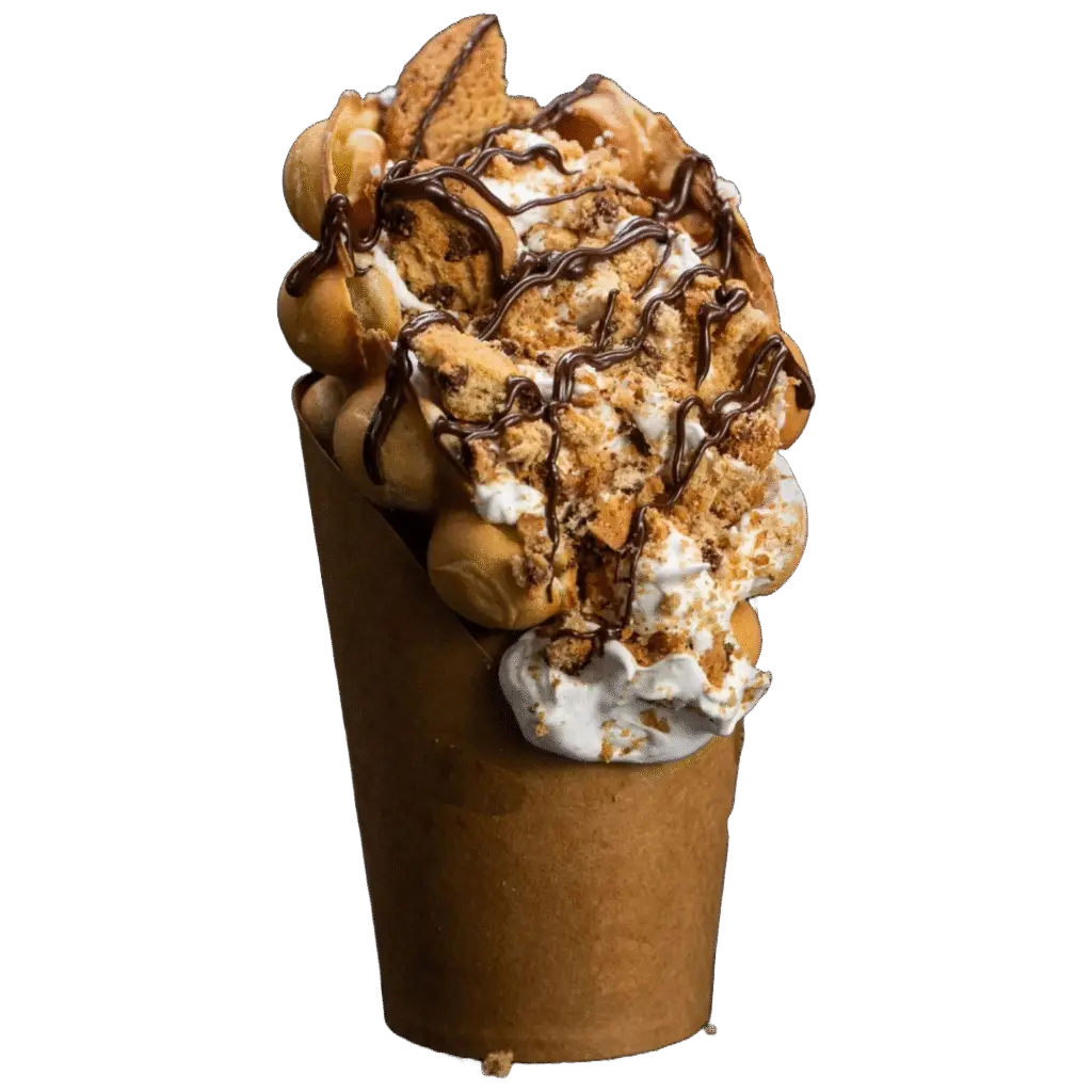 Bubble waffle covered with crumbled chocolate chip cookies, whipped cream, and chocolate drizzle.
