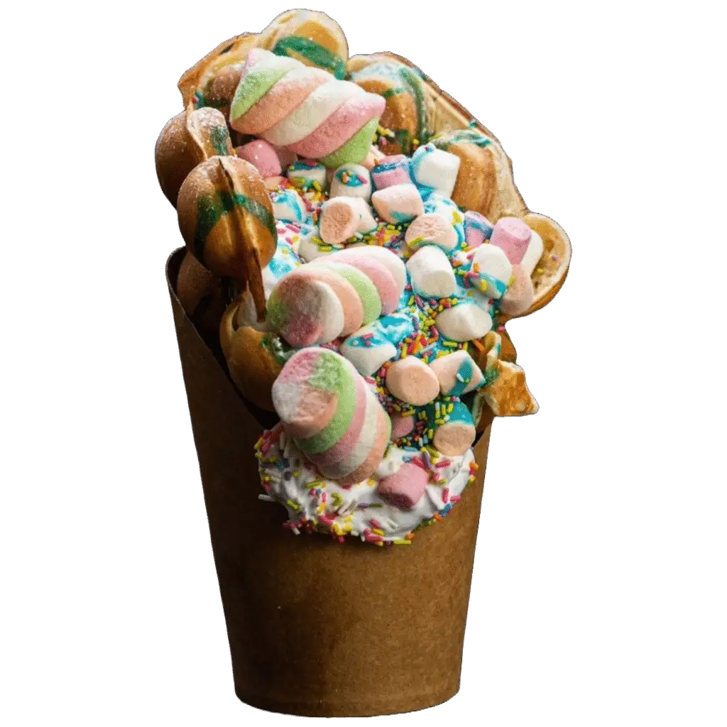 Bubble waffle topped with whipped cream, rainbow sprinkles, marshmallows, and pastel lollipops.